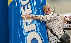 Editor Jenni Spinner on the show floor hugging an Oreo mascot